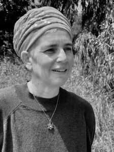 photo of Jacki Edry wearing a necklace with a Jewish star and a head covering.